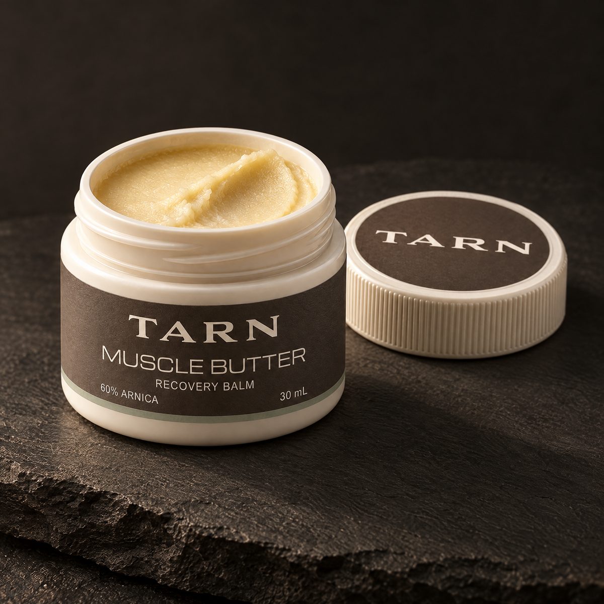 Open jar of TARN Muscle Butter on slate