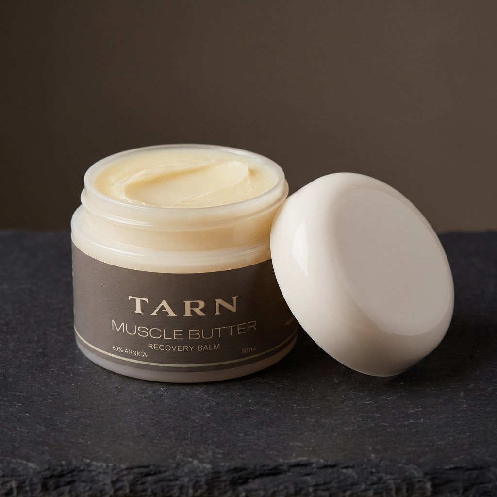 Open jar of TARN Muscle Butter showing the balm, lid beside it
